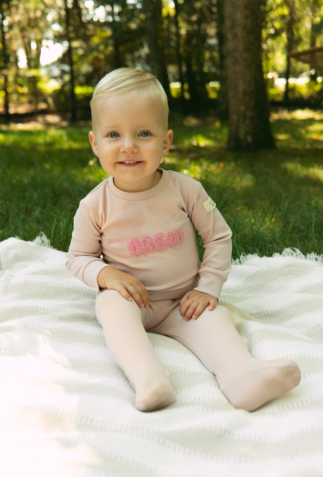 Crew Kids NY pink athletic footie onesie with long sleeves and snap closure.