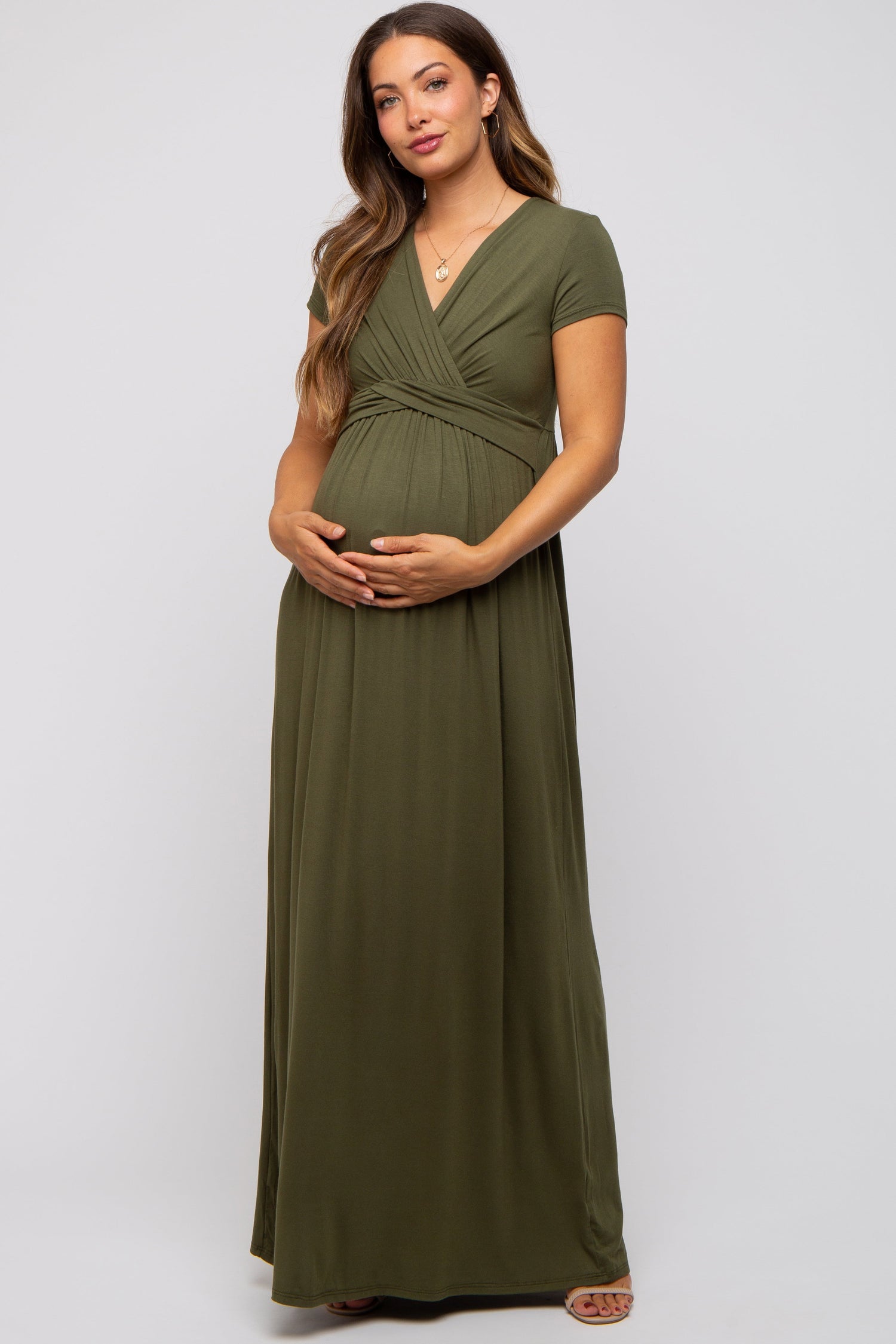 Woman wearing PinkBlush olive draped maternity nursing maxi dress, smiling, showing draped detail