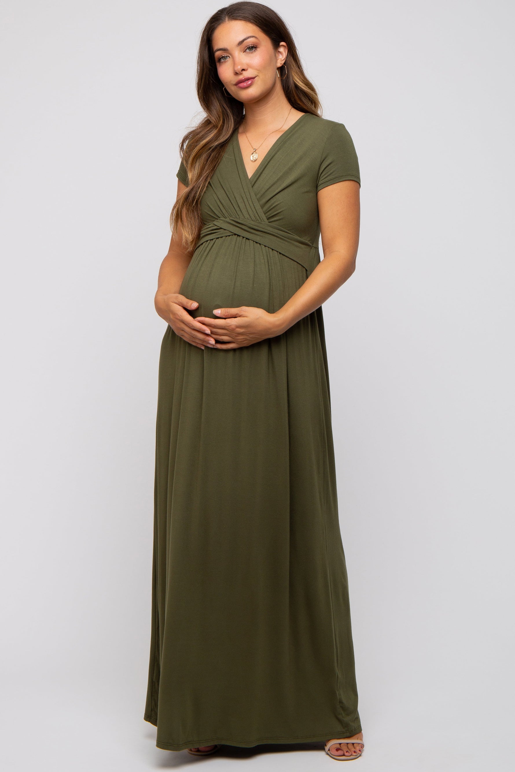 Woman wearing PinkBlush olive draped maternity nursing maxi dress, smiling, showing draped detail