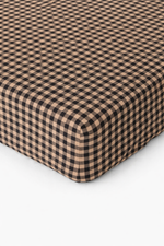 Cookie brown and white gingham pattern organic cotton crib sheet by Little Mae & Co for a baby's crib.