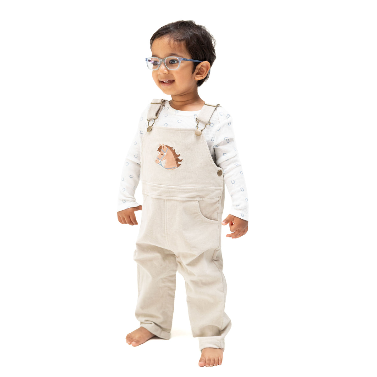 Tan peyote corduroy baby overall with horse head applique on the front and a muslin bandana in the back pocket