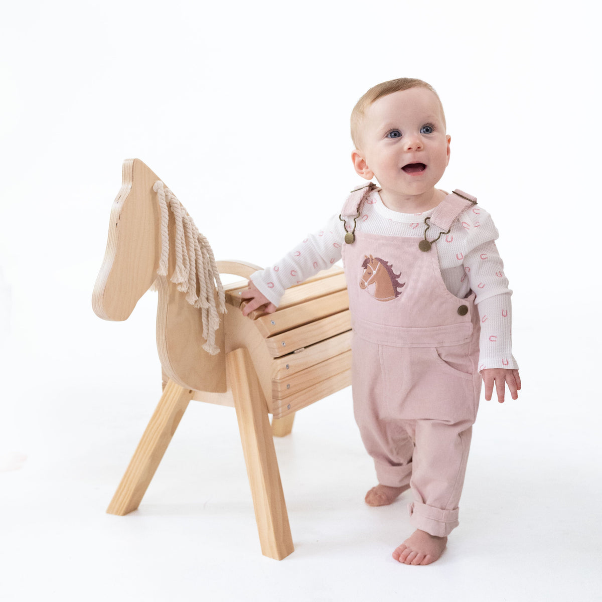 Veiled pink corduroy overalls with adjustable straps, horse head applique on the front and a muslin bandana in the back