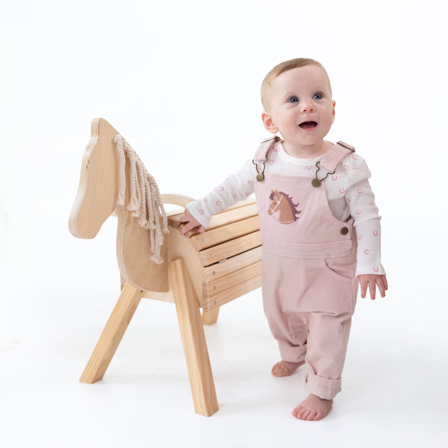 Veiled pink corduroy overalls with adjustable straps, horse head applique on the front and a muslin bandana in the back