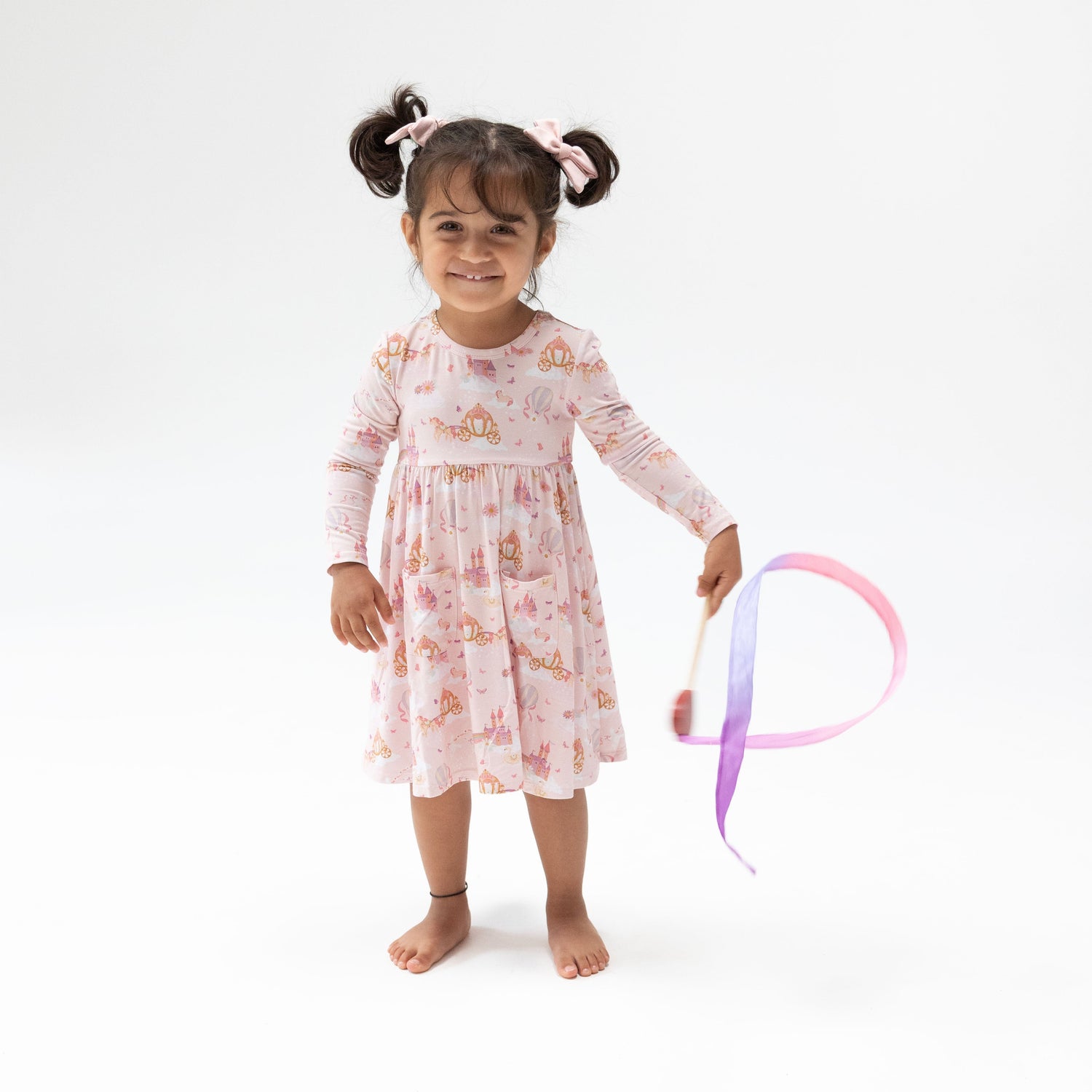 Long sleeve twirly dress with a princess, unicorns, and castle print, paired with matching bike shorts
