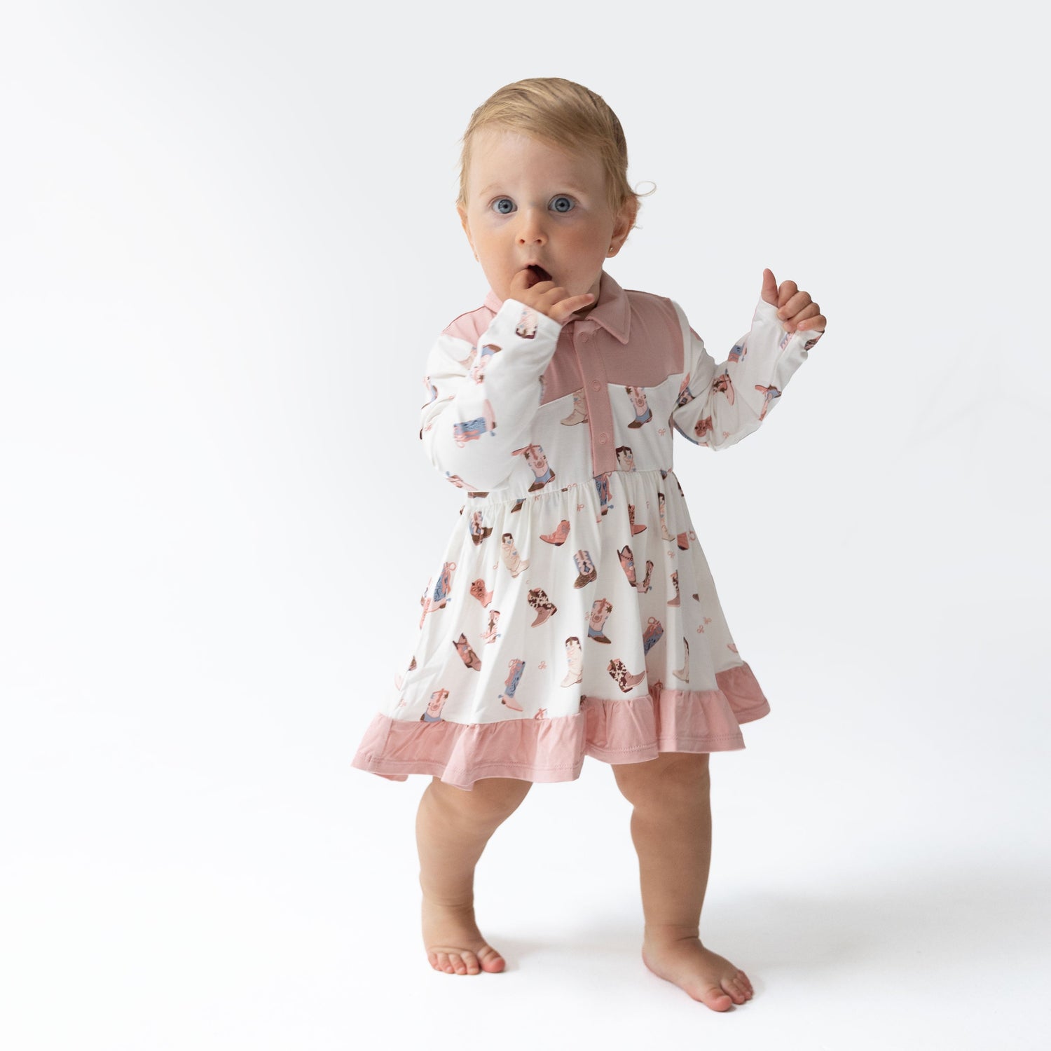 Long sleeve cowgirl-themed baby bodysuit dress with a full twirly skirt and western-inspired print.
