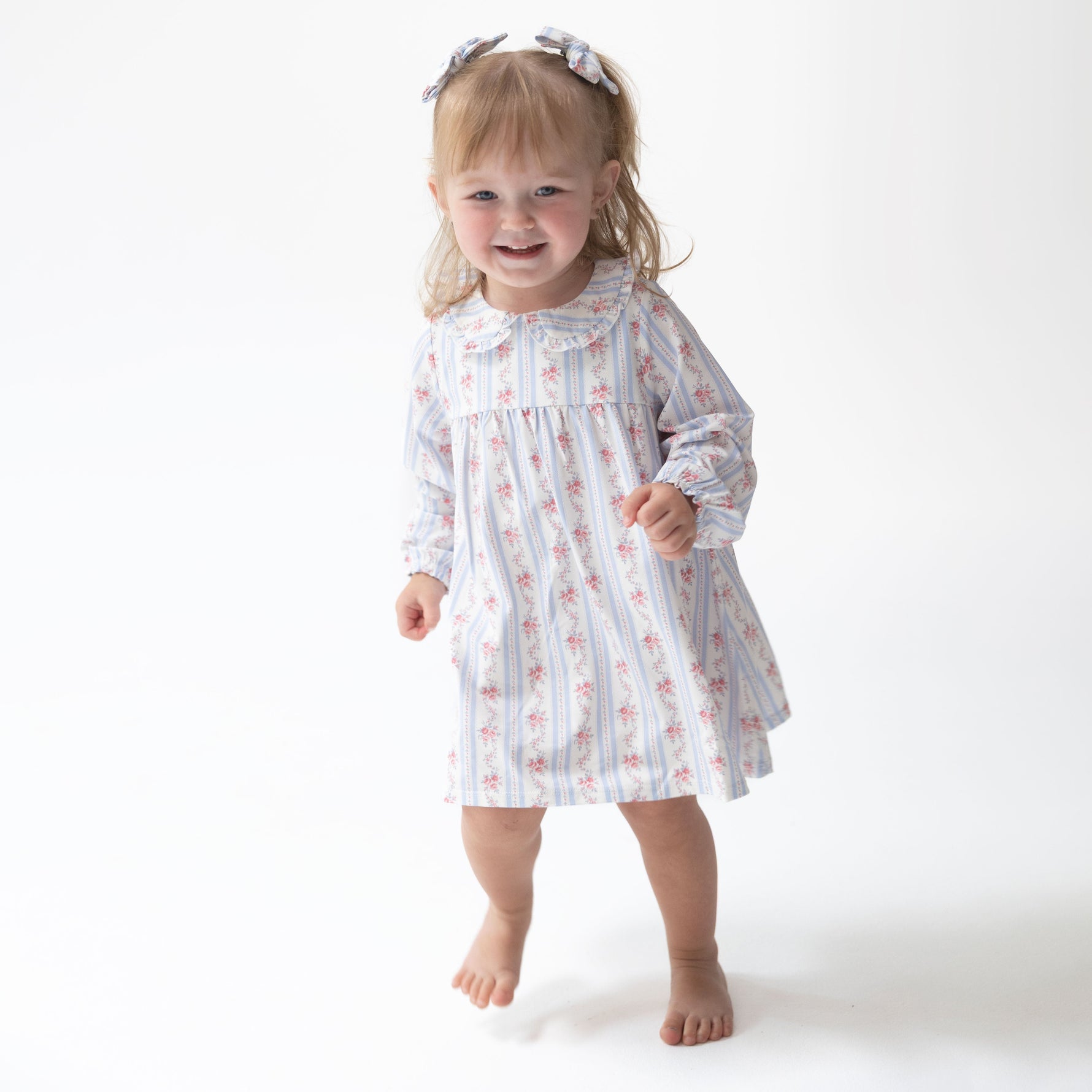 Long sleeve baby dress in floral stripe print with eyelet-trimmed Peter Pan collar, shown with matching bloomer