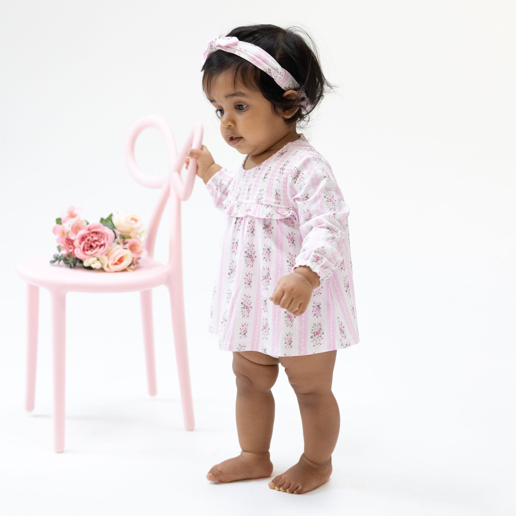 Baby girl's long sleeve smocked bubble romper with attached skirt in a rose stripe print with ruffle trim