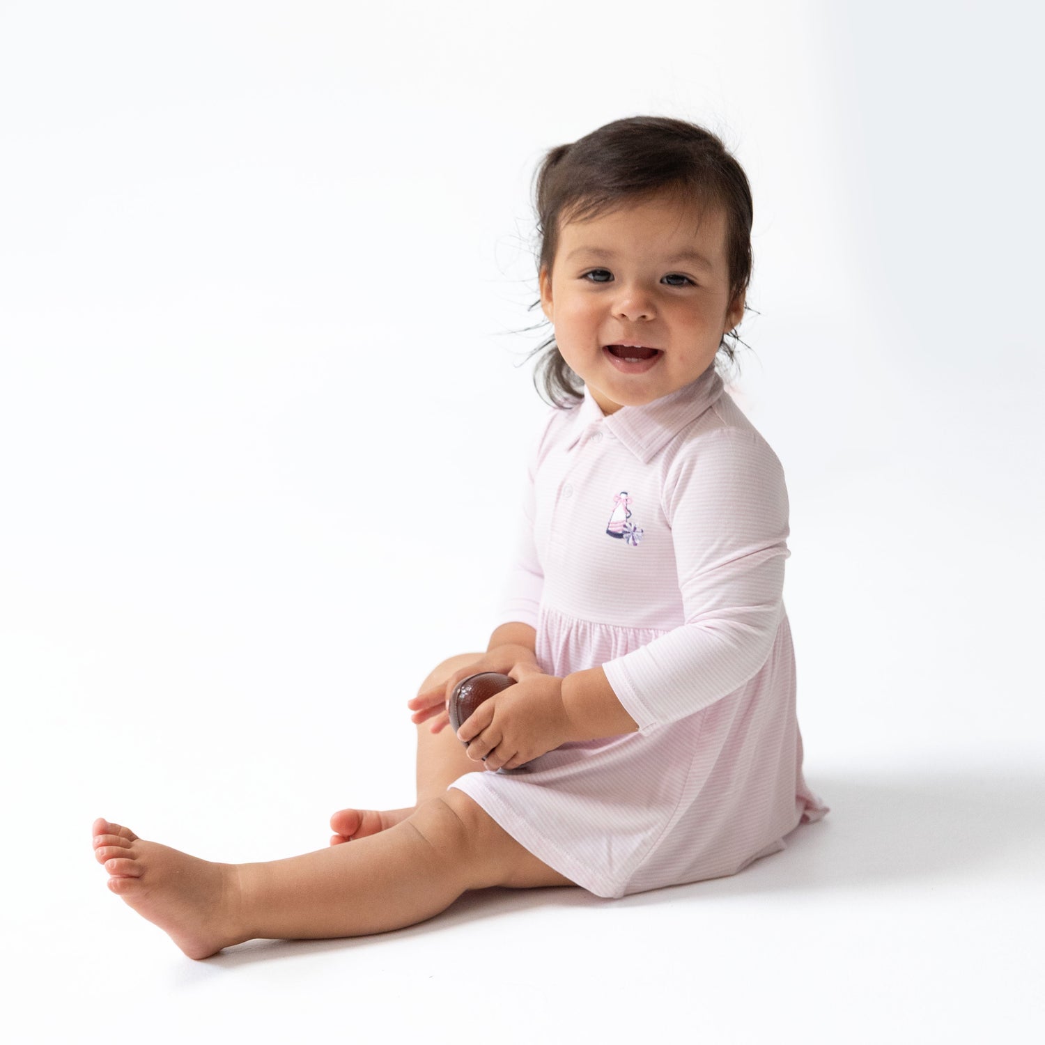 Pink micro stripe long sleeve bodysuit dress with a polo collar and cheer megaphone and pom embroidery on the chest.