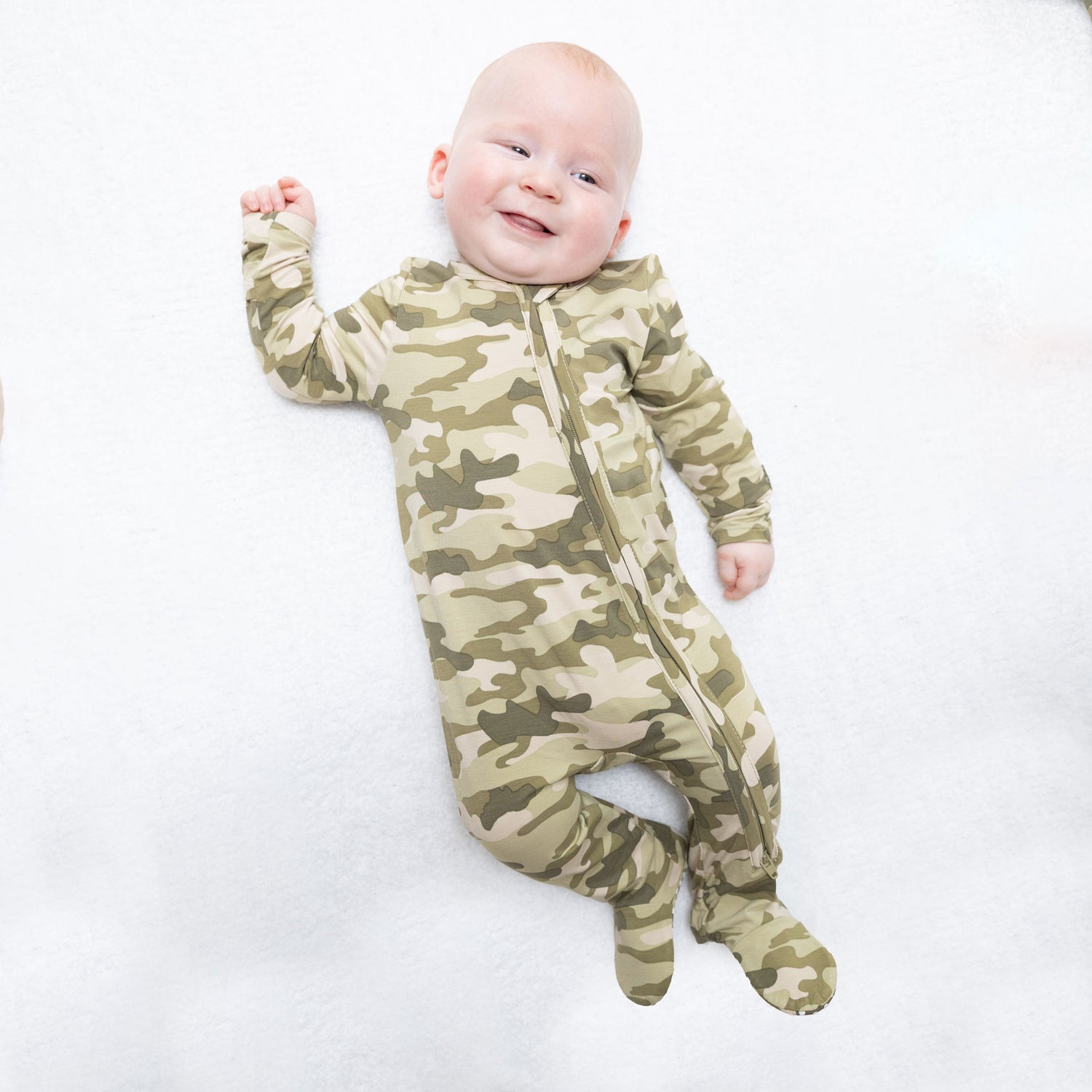 Baby footie pajamas in green and tan camouflage print with two-way zipper and footed legs