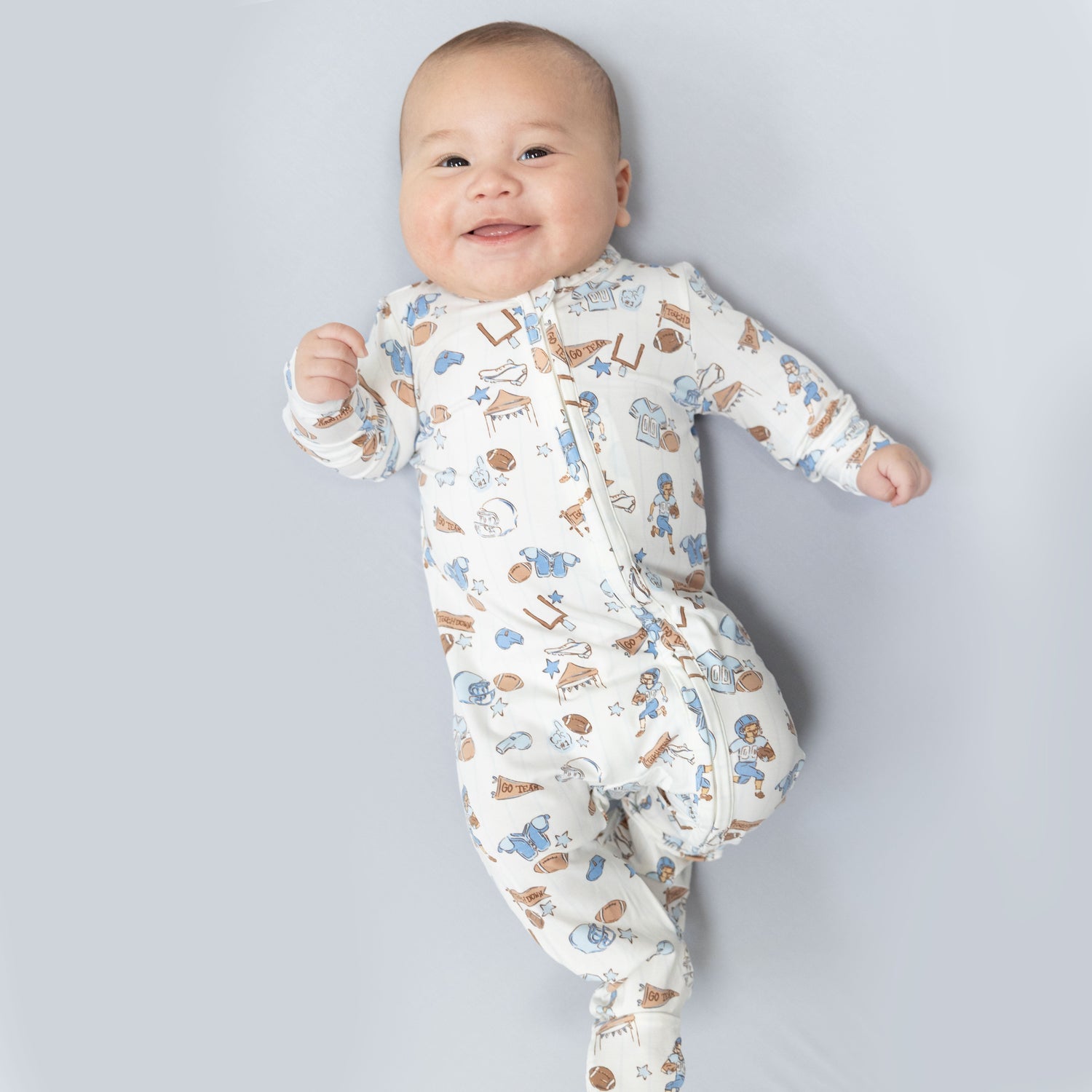 Baby footie pajamas with an all-over football print and a full-length two-way zipper.