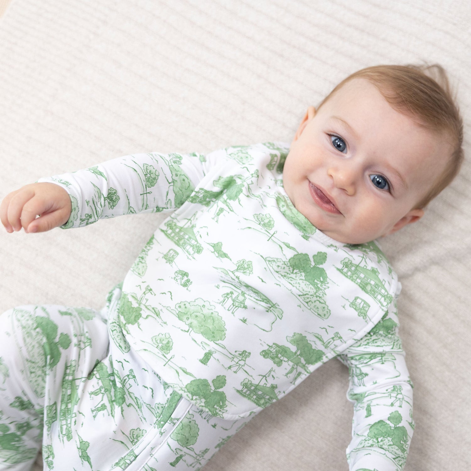 Feeding bib in green golf toile print with a fastening at the back of the neck