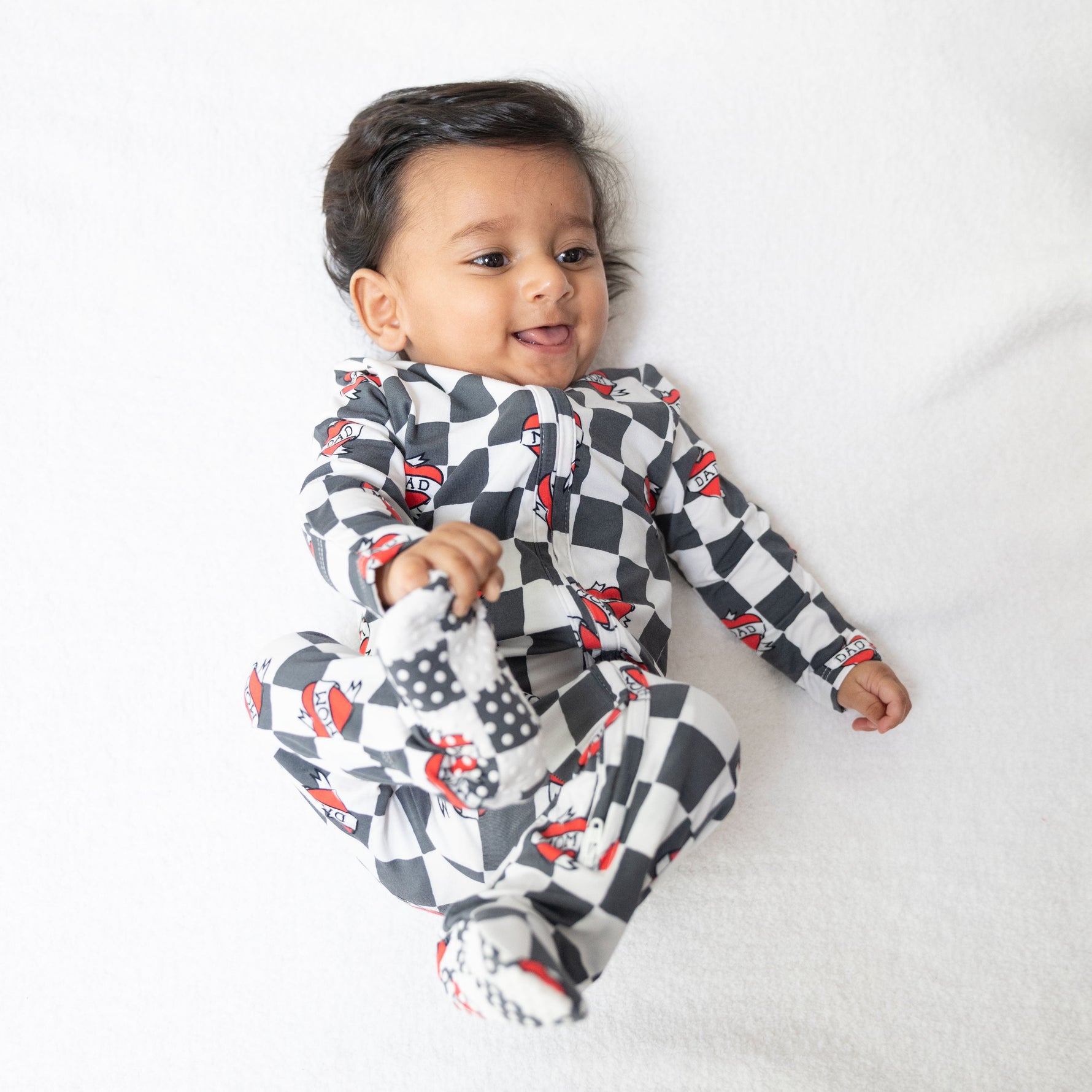Baby footie pajama with black and white heart tattoo check print, two-way zipper and fold-over cuffs