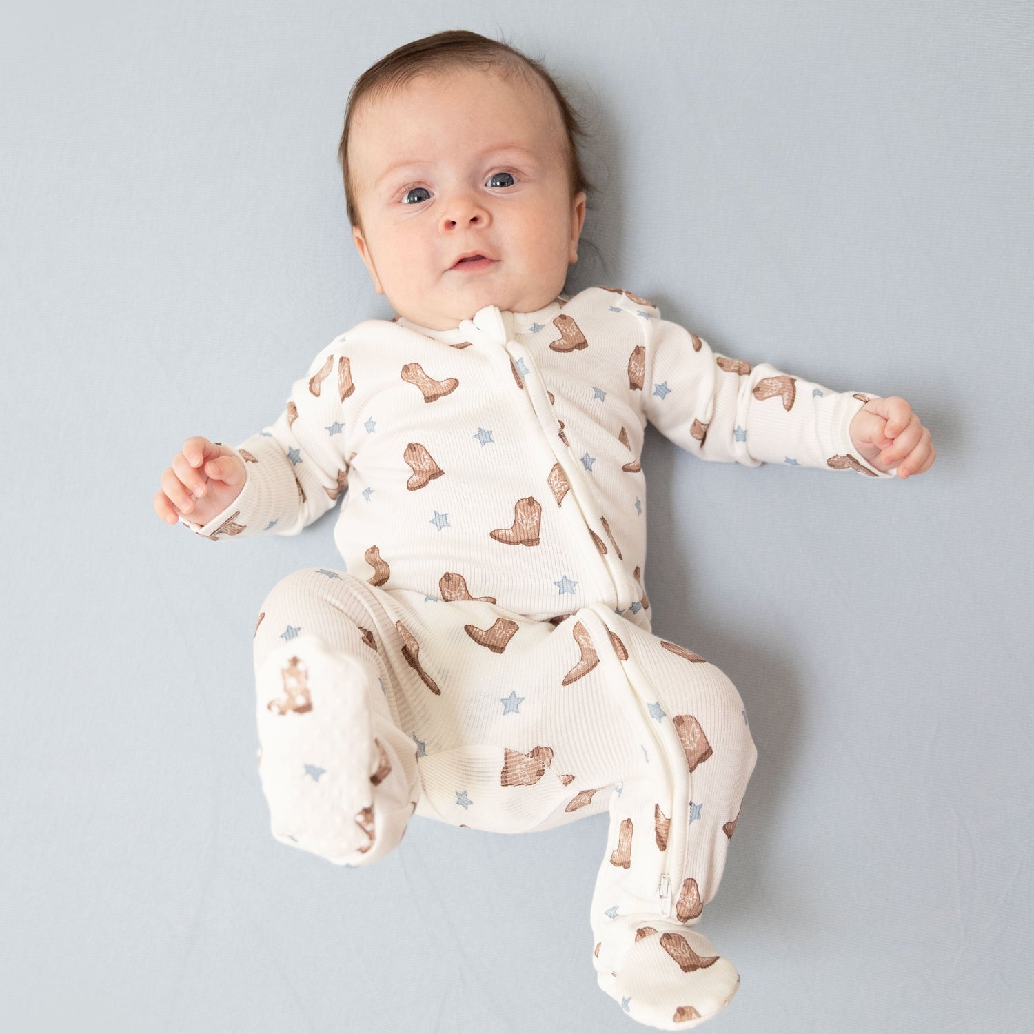 Footie pajamas in soft ribbed knit with an allover mini cowboy boots print and footed legs.