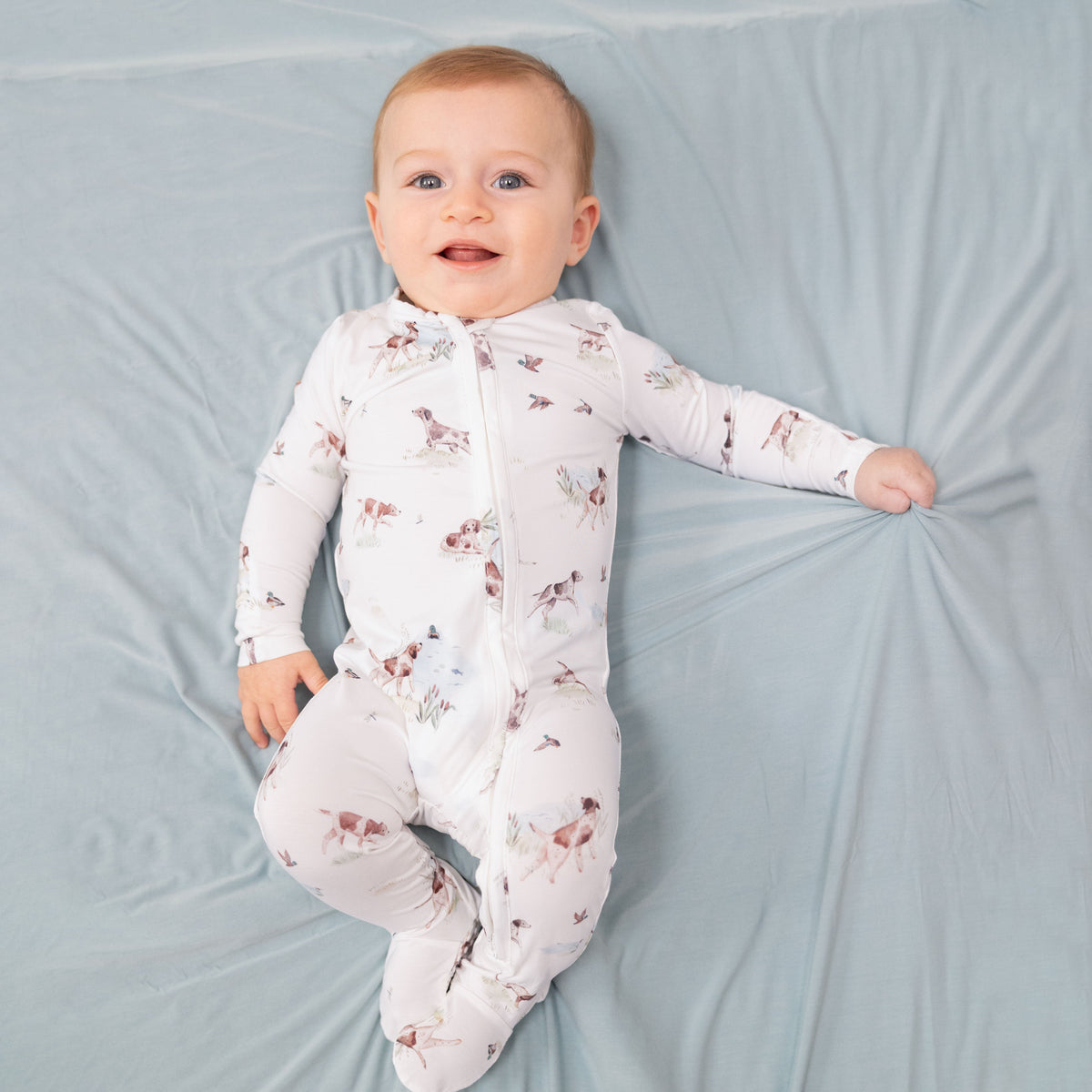 Baby footie pajamas with pointer dog and duck print, two-way zipper down the front, and footed grippers.