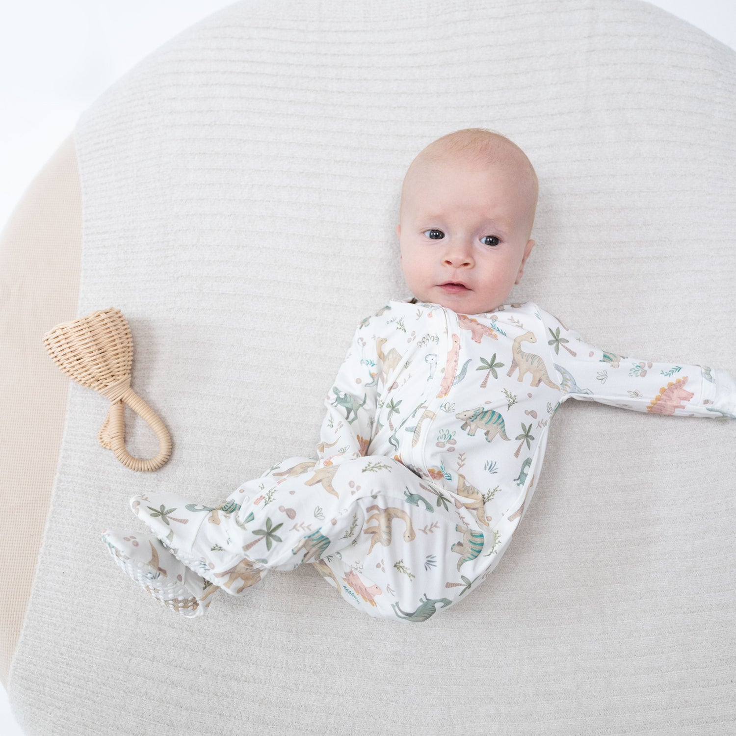 Baby footie pajamas in a sweet dinosaur print with a full-length front zipper and footed legs.