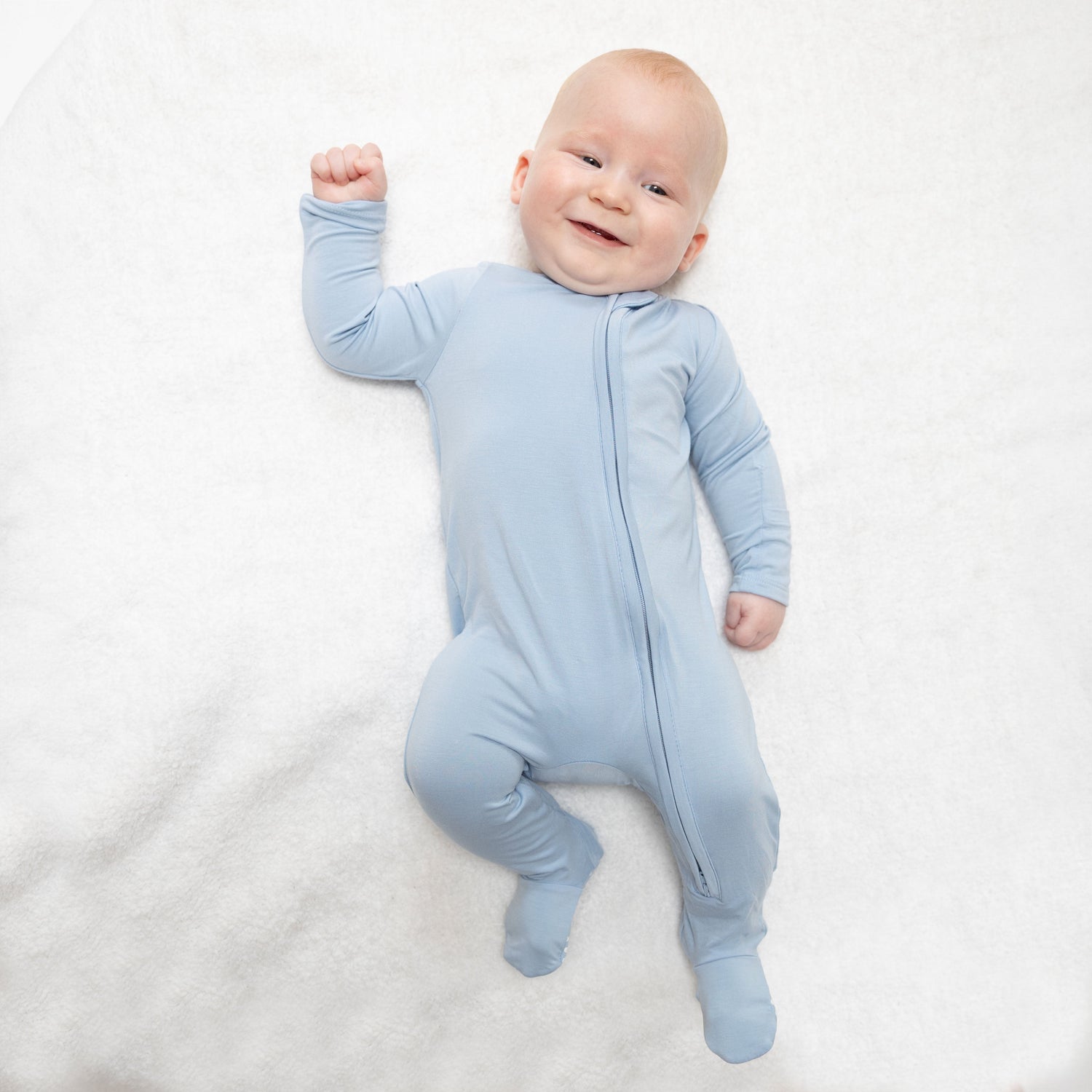 Footie pajamas in solid Blue Fog with a full-length two-way zipper and footed legs.