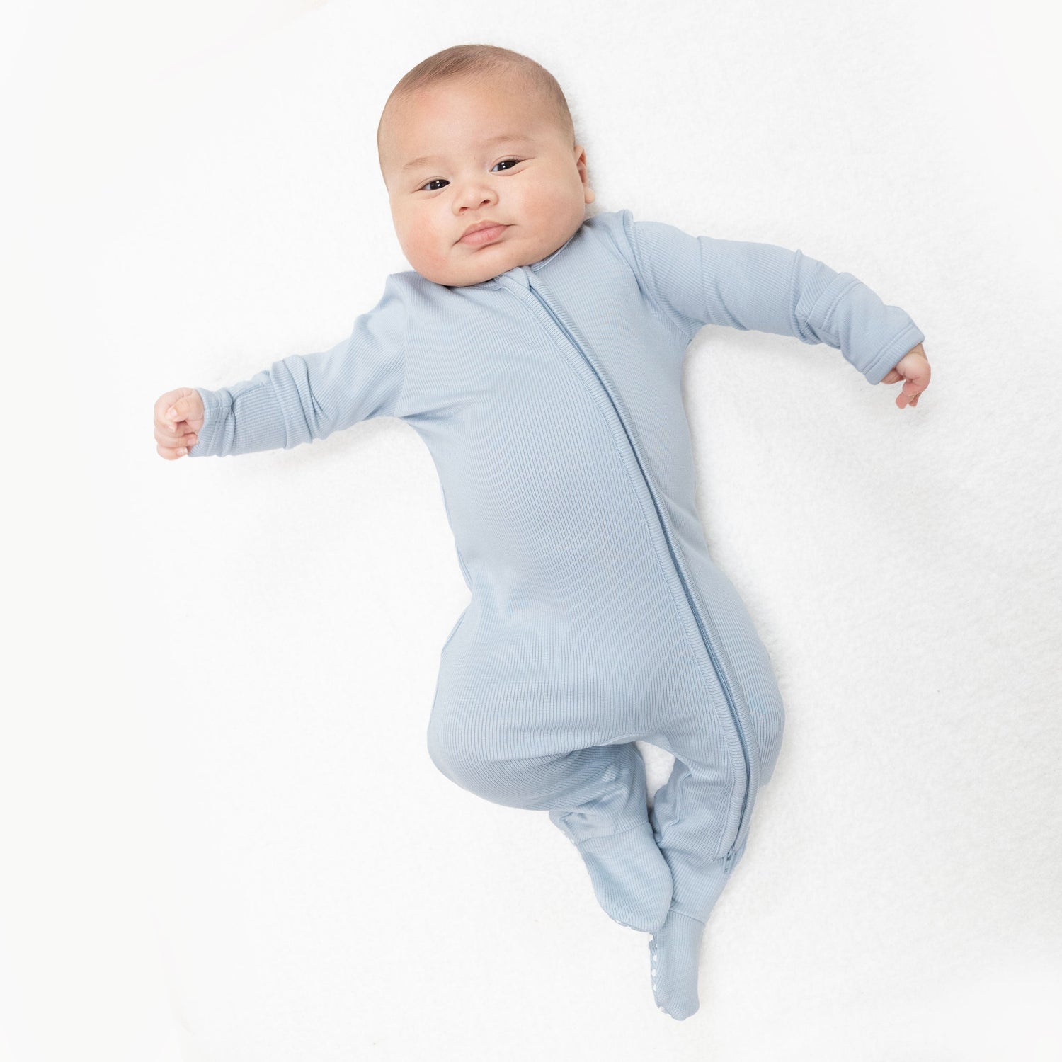 Baby footie in solid sheer blue ribbed fabric with a two-way zipper, fold-over cuffs, and gripper feet