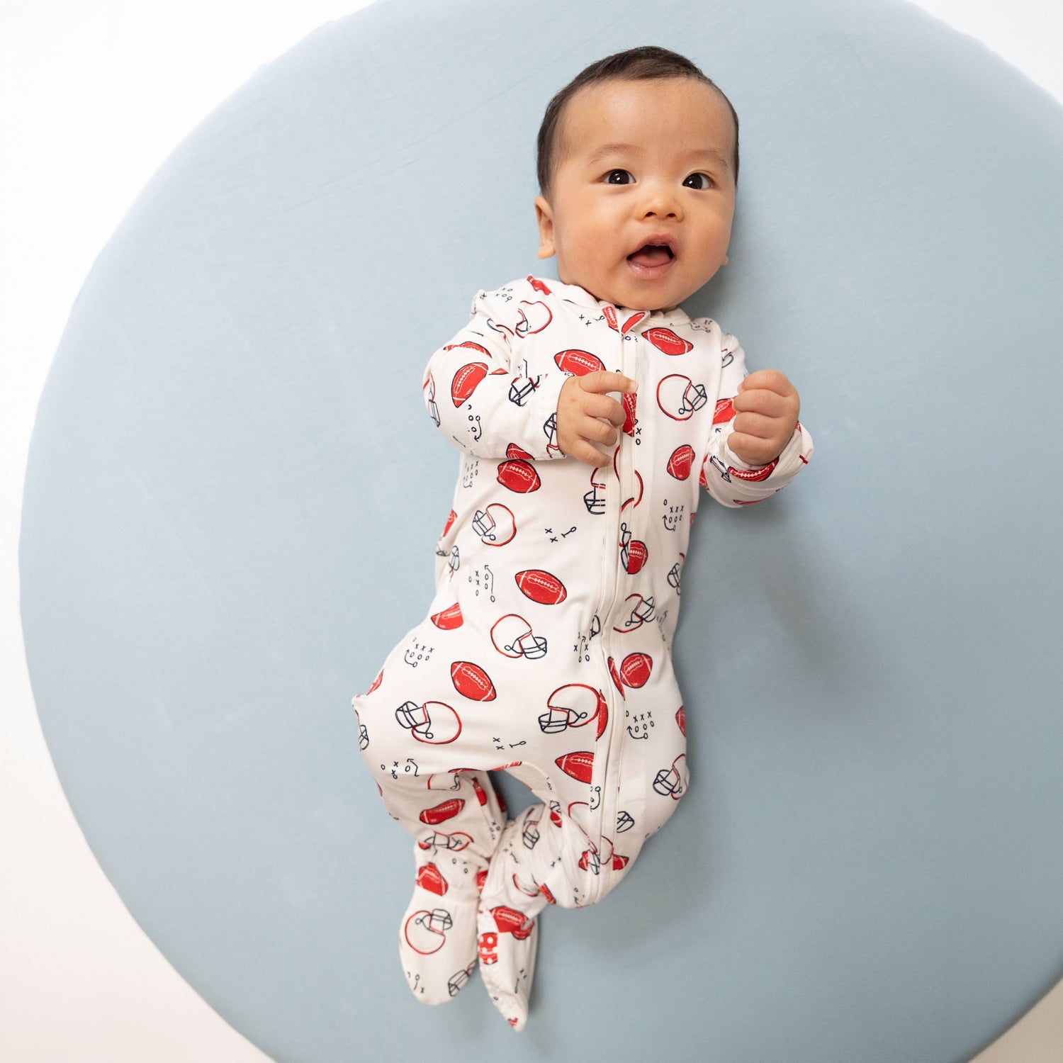 Footie pajamas in a football-themed Touchdown Time print with a full-length two-way zipper and footed legs