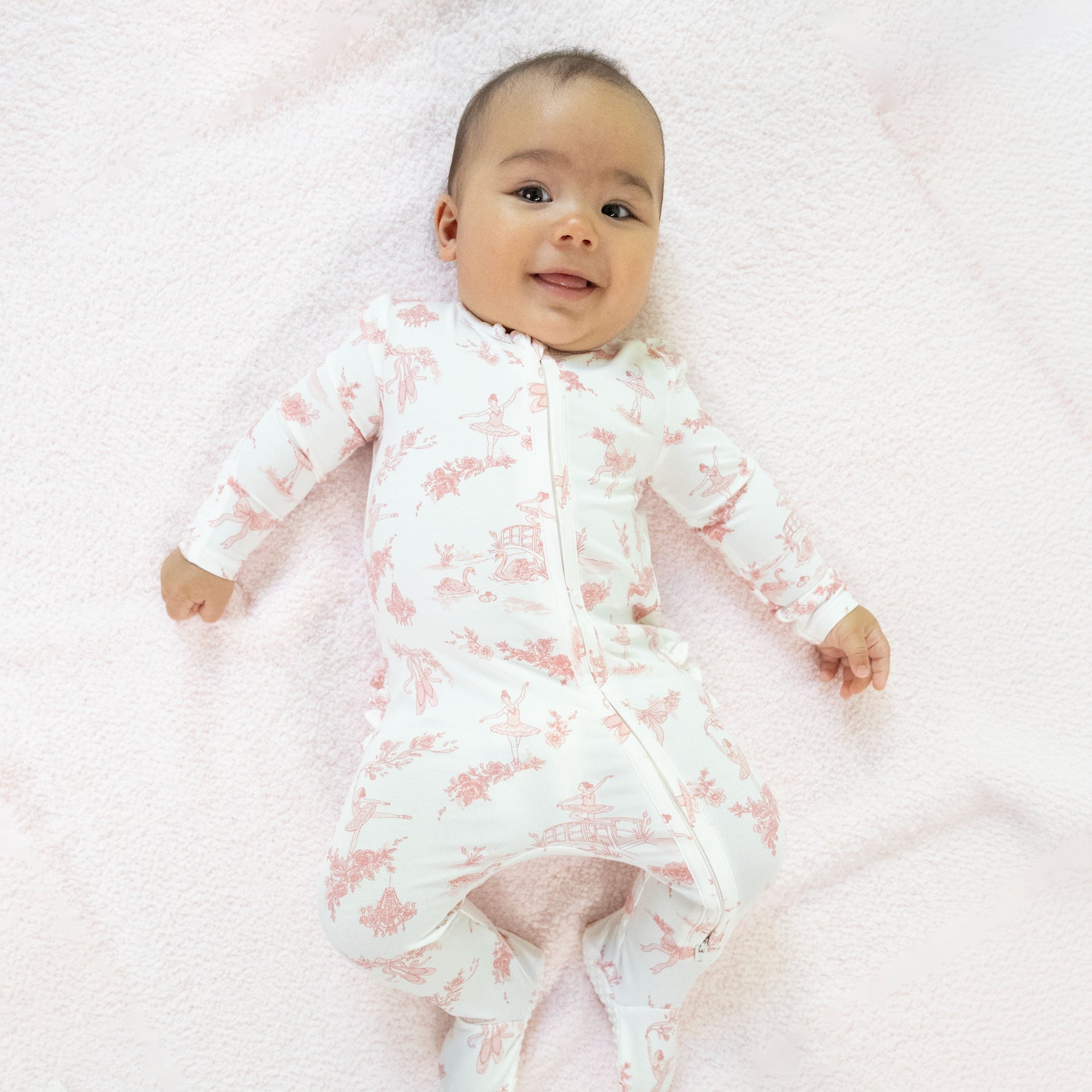 Baby footie pajama in ballet toile print with ruffle back detail and two-way front zipper