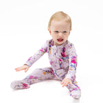 Footie pajamas in a dahlia floral print with a ruffle back detail and full-length two-way zipper.