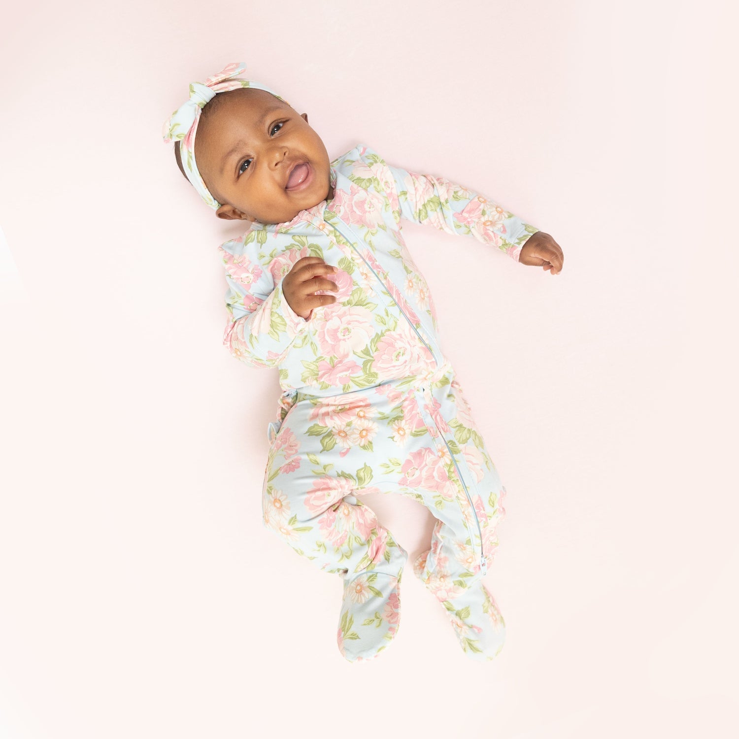 Baby footie in Angeline floral print with ruffle back detail and full-length front zipper.