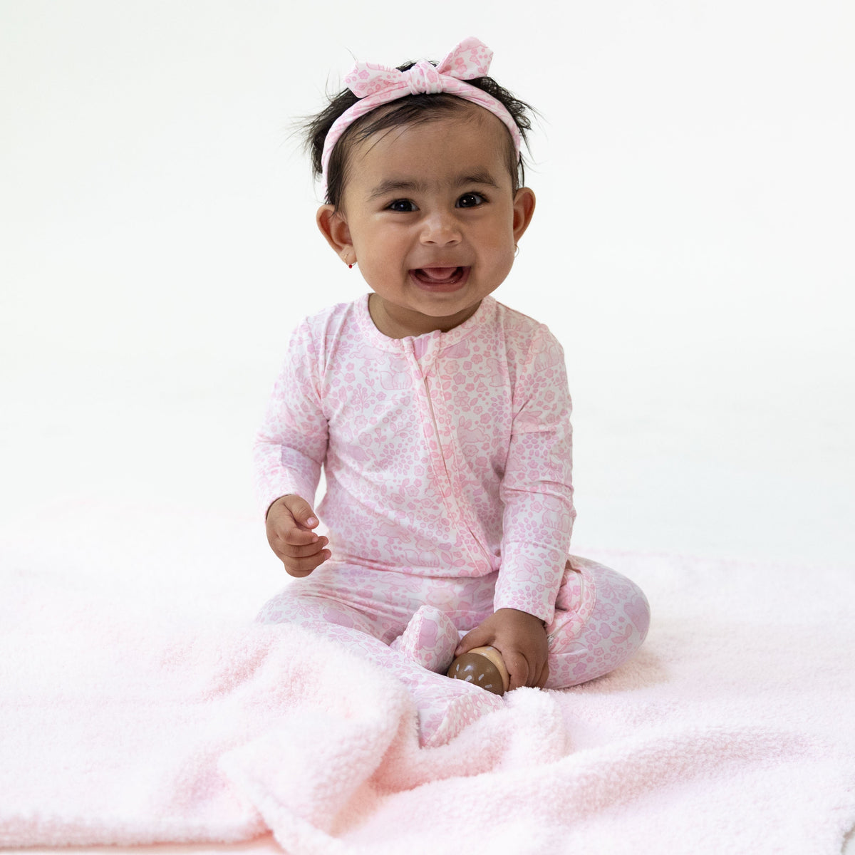 Baby footie pajamas in a woodland animal print with ruffle back detail and two-way front zipper