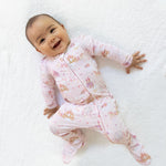 Footie pajamas with a princess unicorns and castle print, ruffle back detail, and front zipper