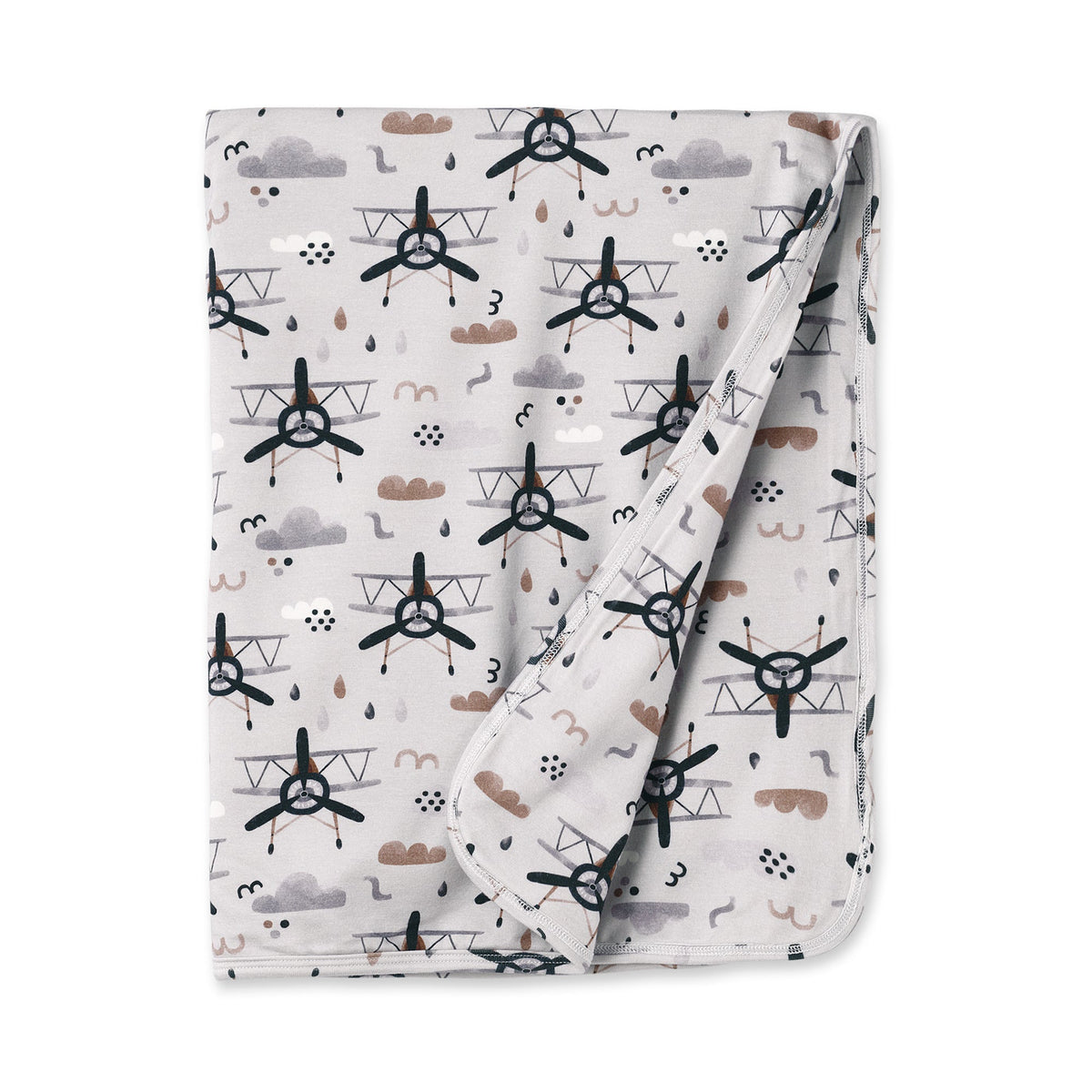 Baby stroller blanket with a print of propeller airplanes and clouds