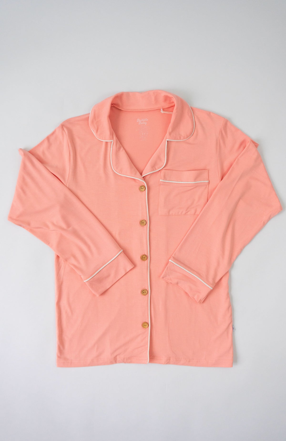Peach button-up pajama top with collar and long sleeves in a soft warm pink tone
