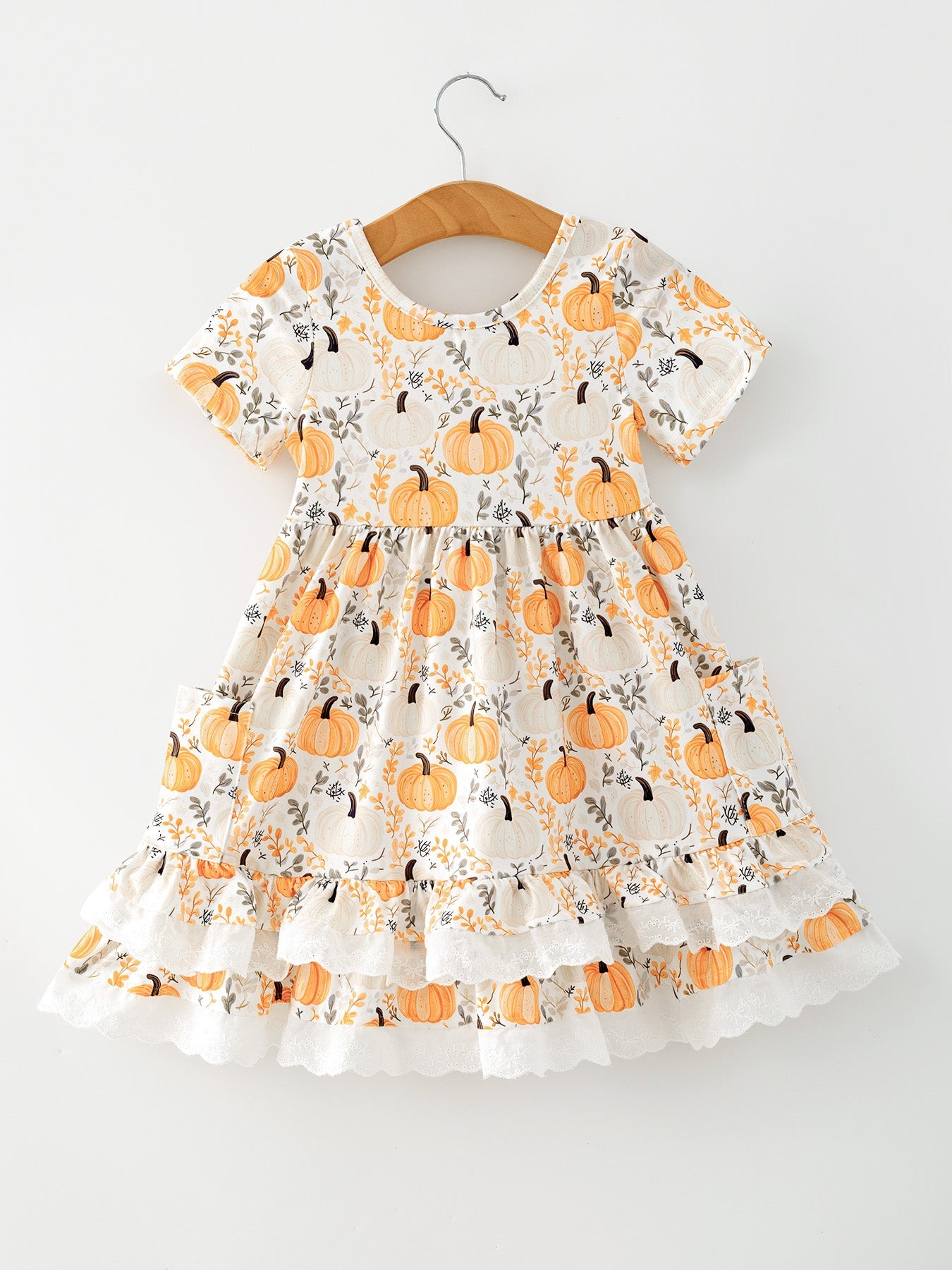 Orange girls dress with pumpkin patch print, front pockets, and lace trim along the hem.