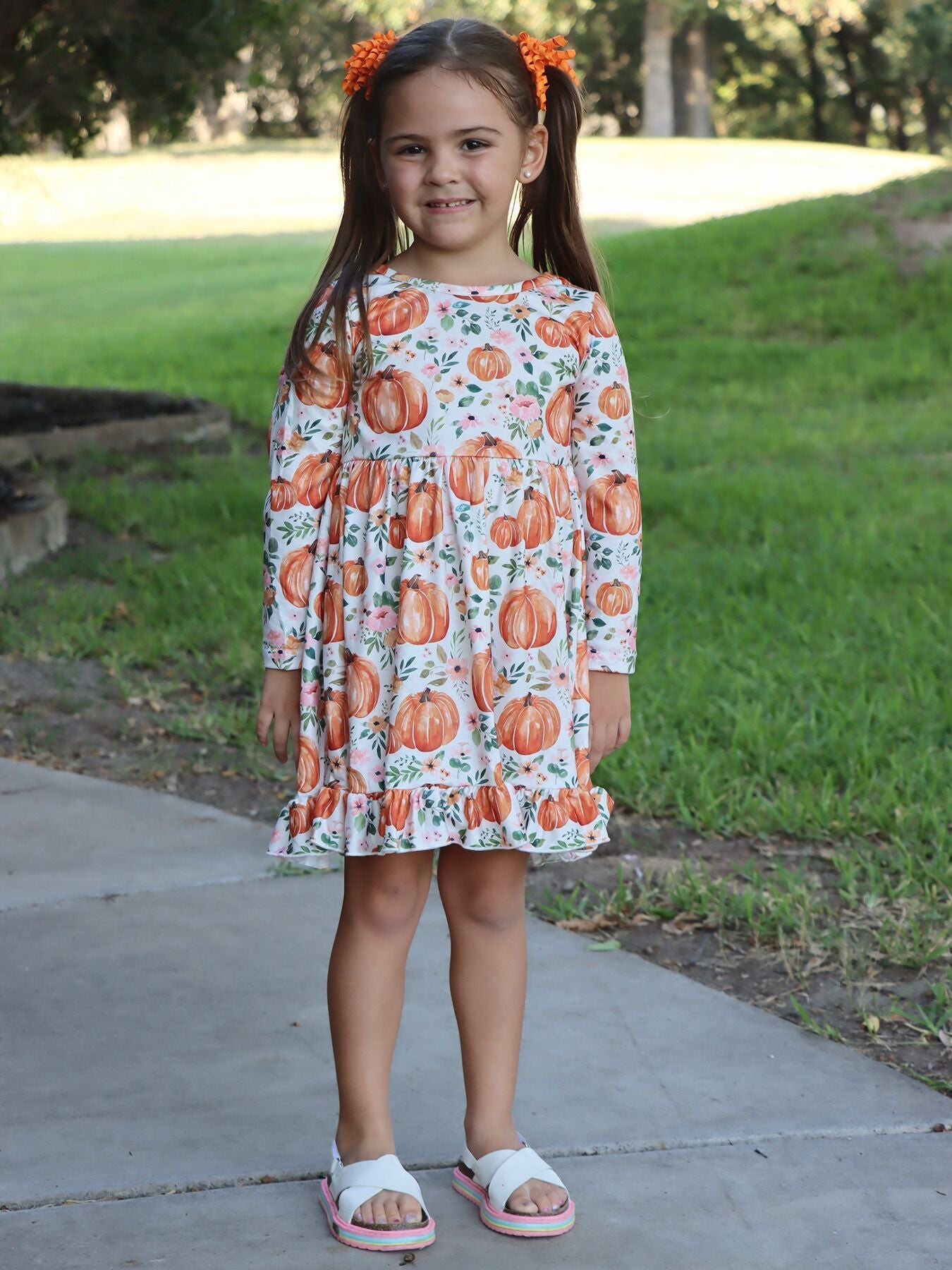 Girls long sleeve dress with an all-over pumpkin print in fall colors.