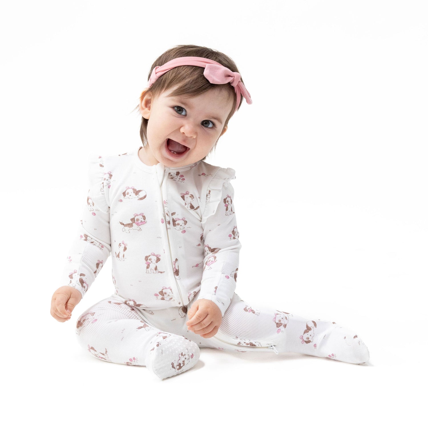 Pink ruffle-sleeve zipper footie with a puppy print, fold-over cuffs, and gripper feet.