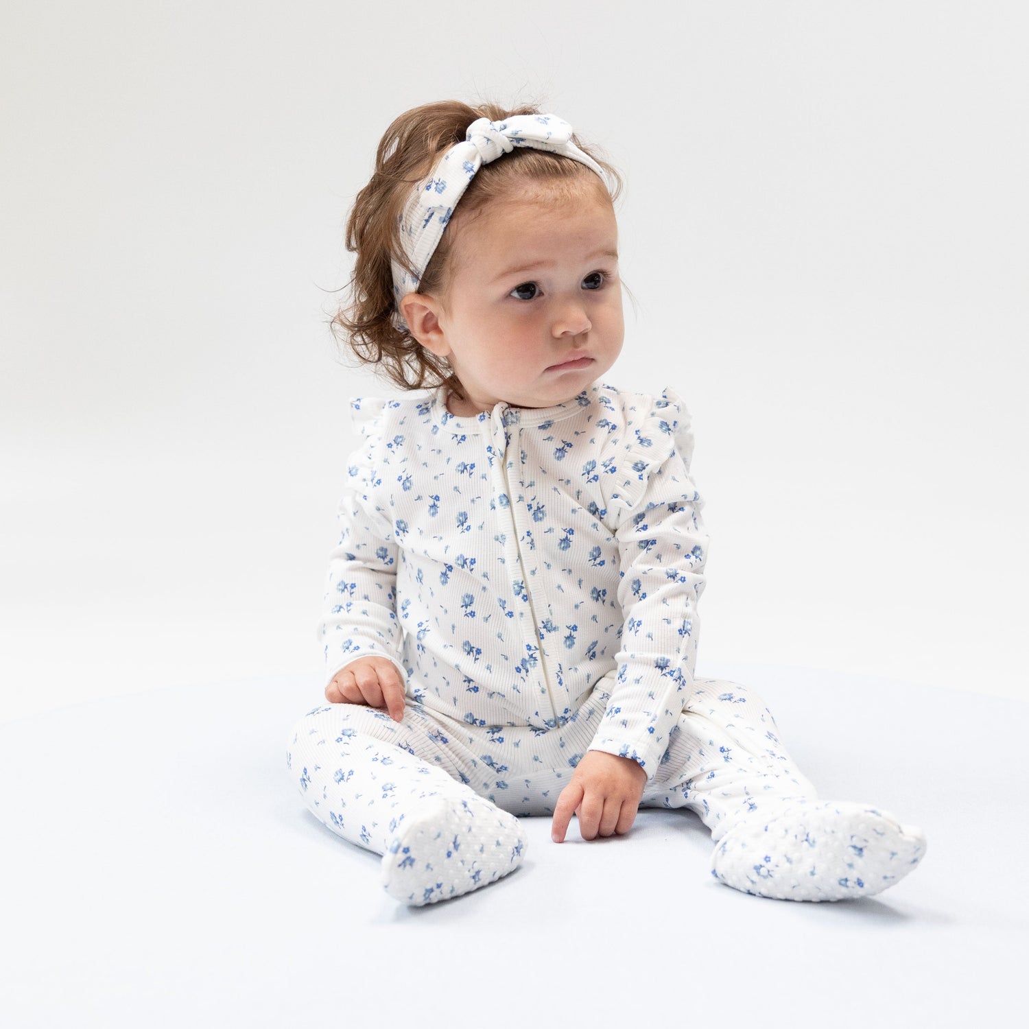Ruffle-sleeve zipper footie in the Joli Rosette rose print with fold-over cuffs and footed grippers.