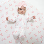 Baby footie pajamas in a Pretty Bows print with ruffle sleeves, front zipper, and footed grippers.