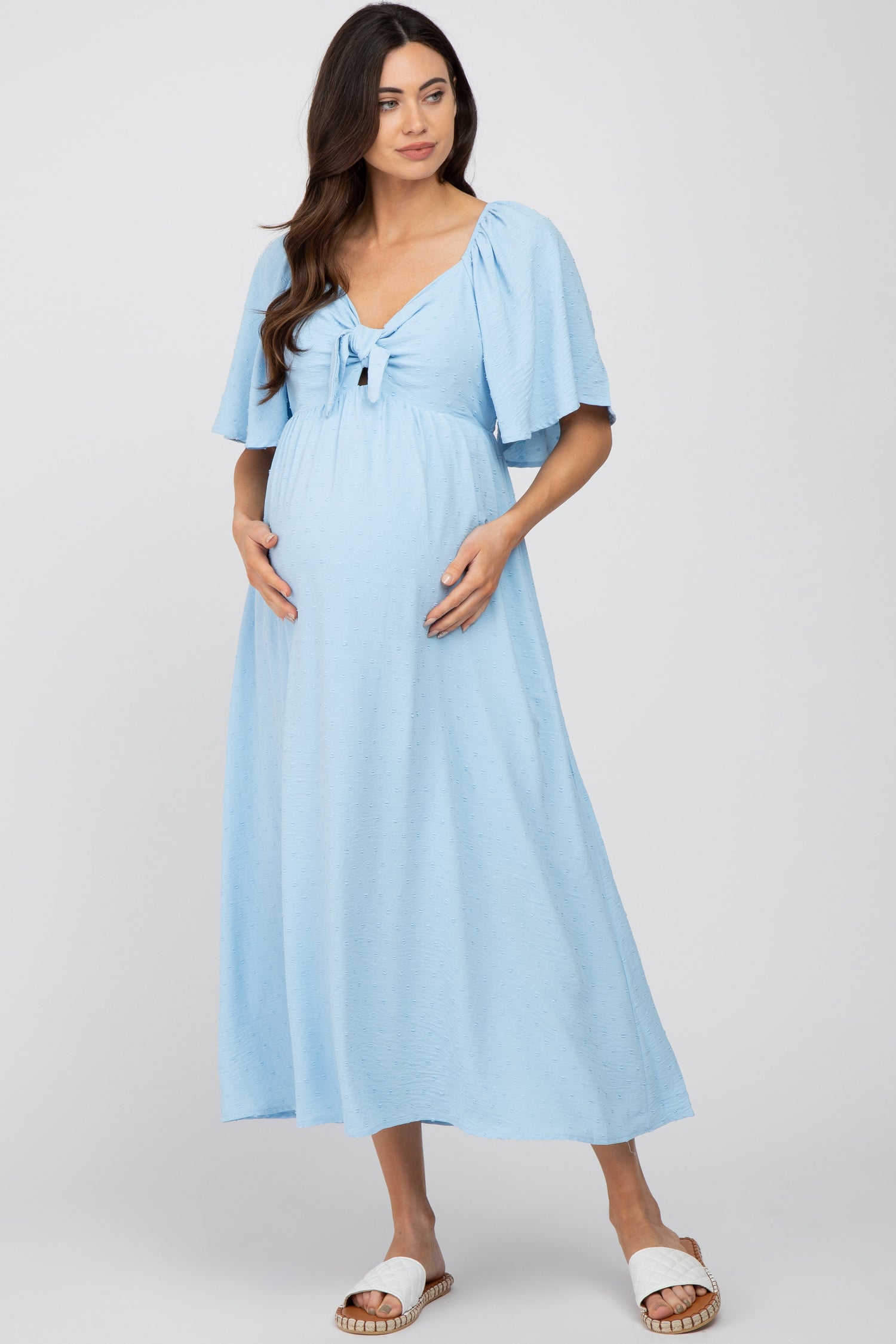 Light blue textured dot maternity midi dress with v-neckline, front tie, cutout and short ruffle sleeves