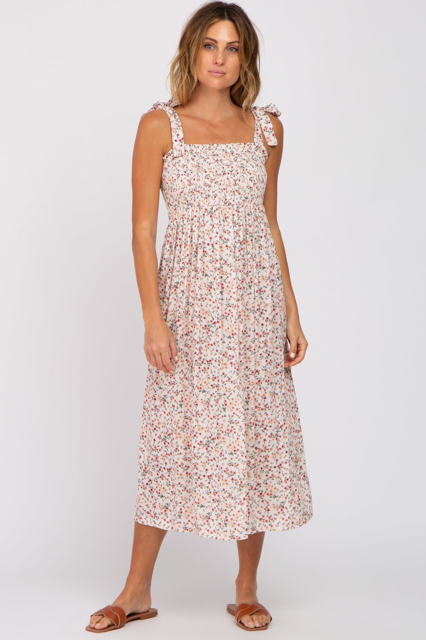 Cream floral midi dress with smocked top, square neckline, and self-tie straps, shown with sandals.