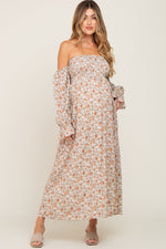 Taupe floral off-the-shoulder long sleeve maternity maxi dress with a smocked bodice and flowing skirt.