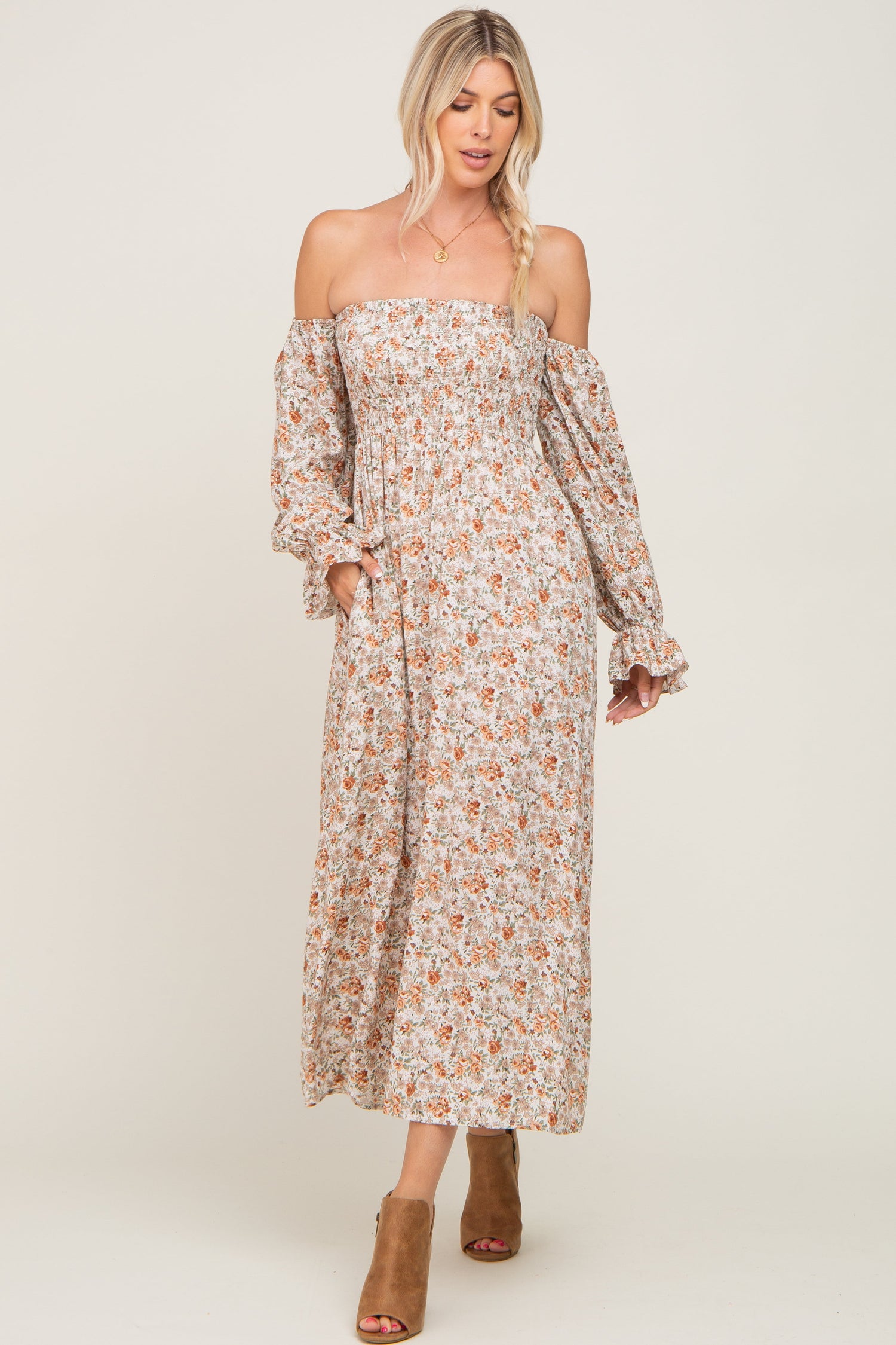 Taupe floral off-the-shoulder long sleeve maxi dress with a smocked bodice, shown with heeled sandals.