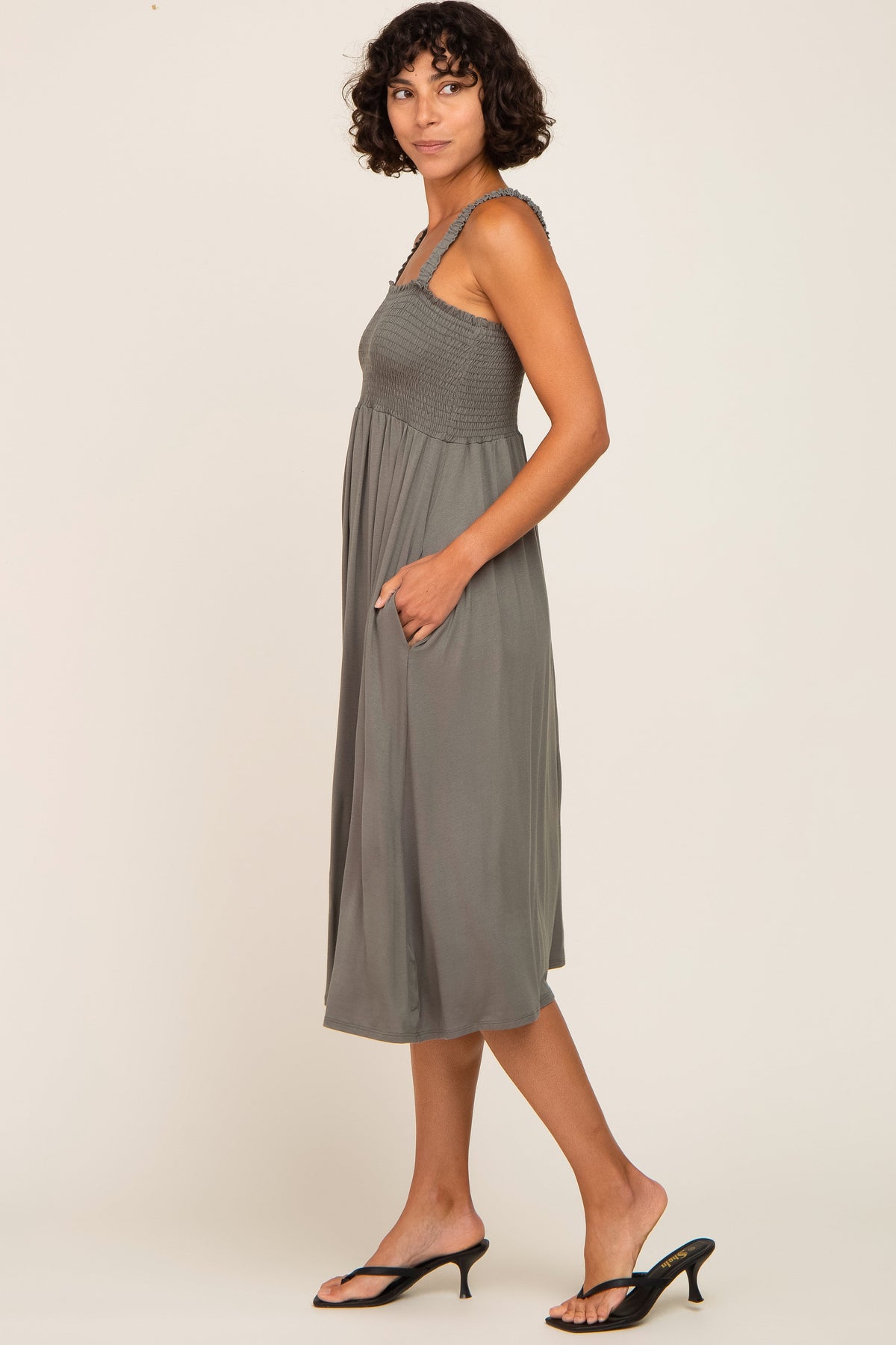 Model wearing an Olive Smocked Ruffle Strap Midi Dress, perfect for maternity and postpartum comfort.