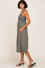 Model wearing an Olive Smocked Ruffle Strap Midi Dress, perfect for maternity and postpartum comfort.