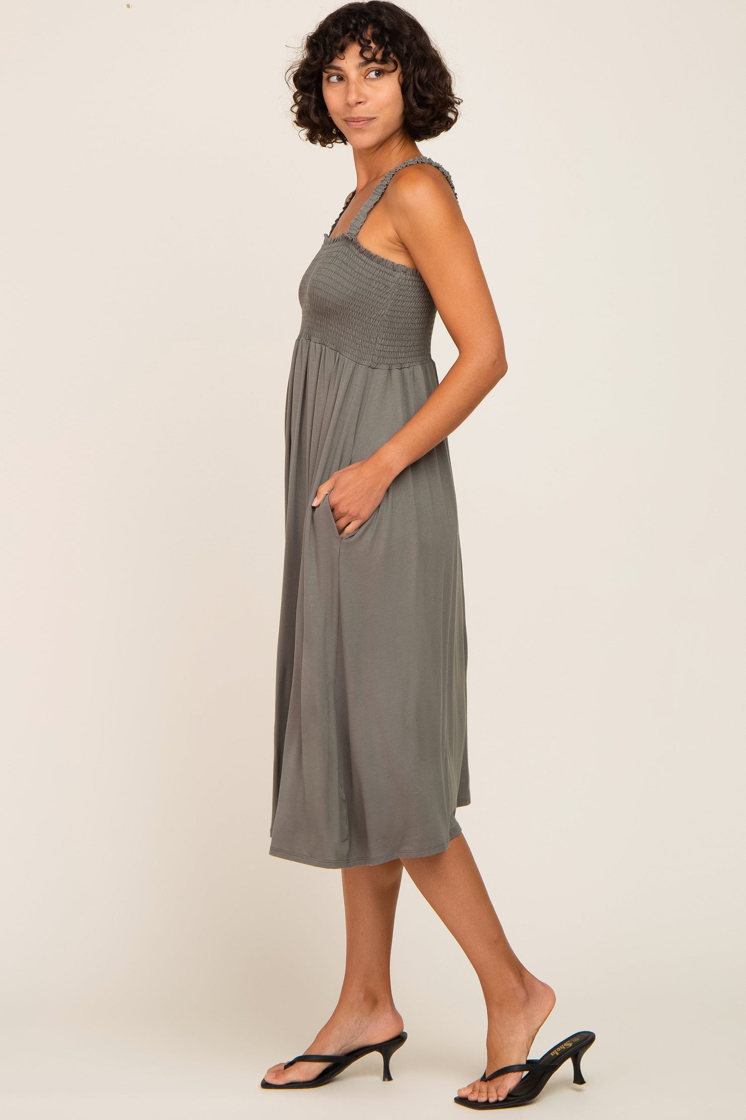 Model wearing an Olive Smocked Ruffle Strap Midi Dress, perfect for maternity and postpartum comfort.