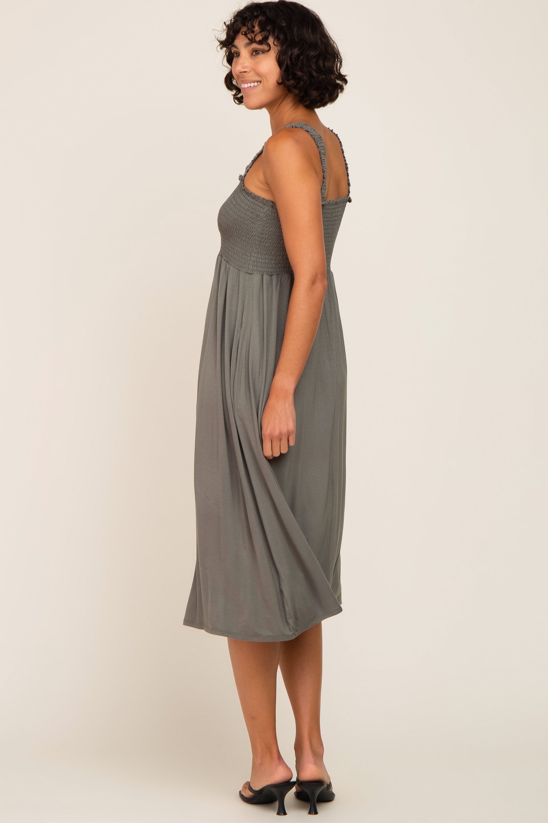 Model wearing an Olive Smocked Ruffle Strap Midi Dress, perfect for maternity and postpartum comfort.