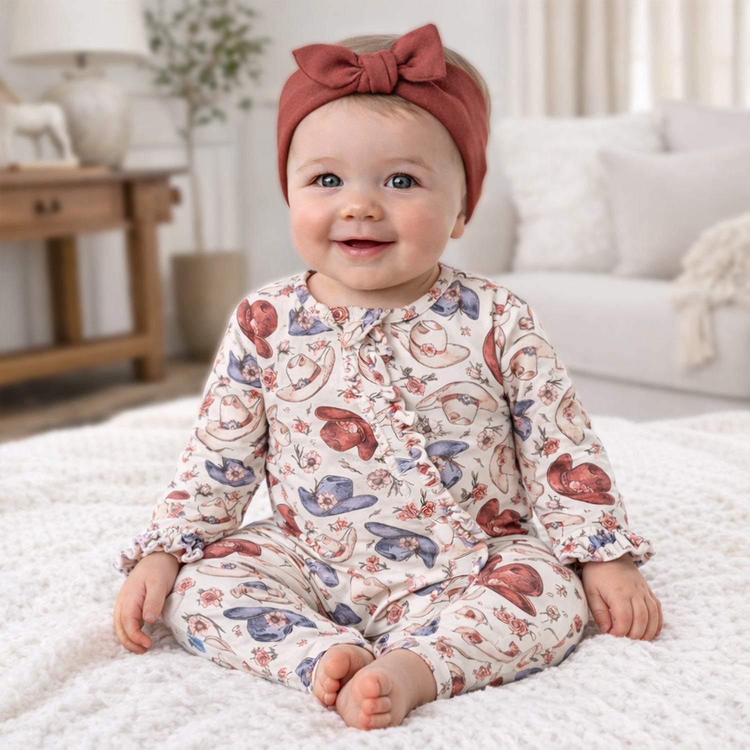 Baby zipper romper in Wildflower Rodeo print with cowboy hats and blooms, full-length zipper and convertible footie cuffs.
