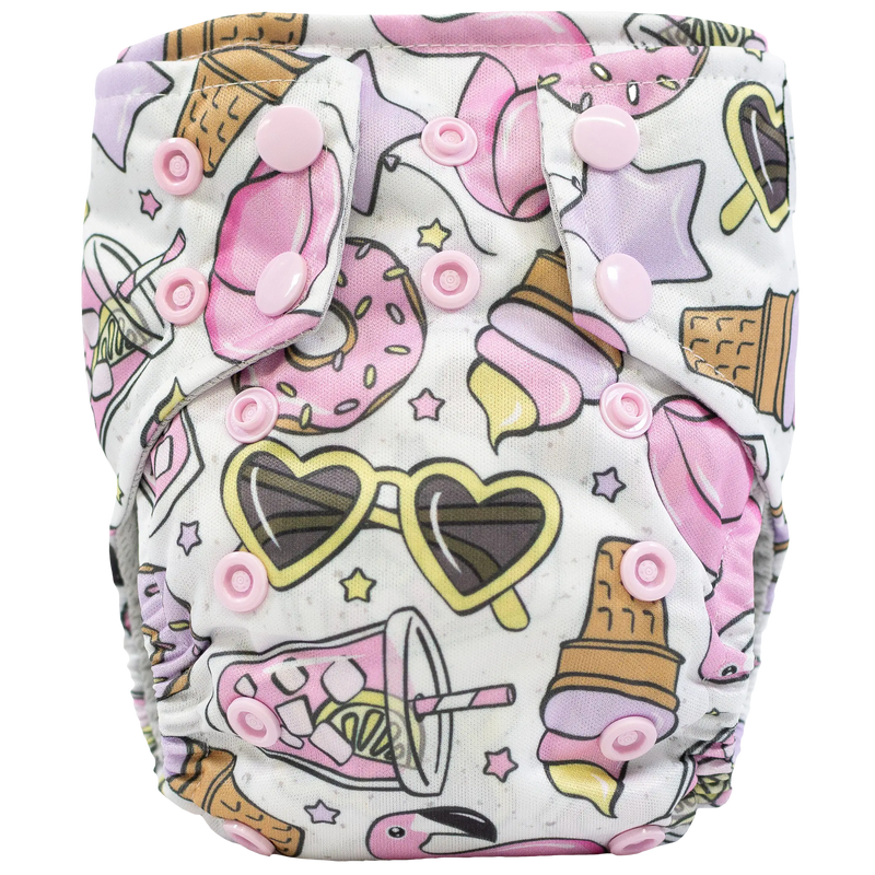 Tiny Tushies Newborn AIO cloth diaper with colorful print and pink snaps.