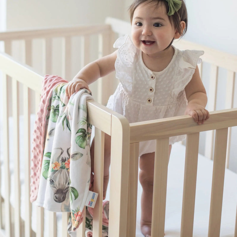Baby & Toddler Minky Blanket with Africa Animals pattern in crib, soft and sensory-friendly.
