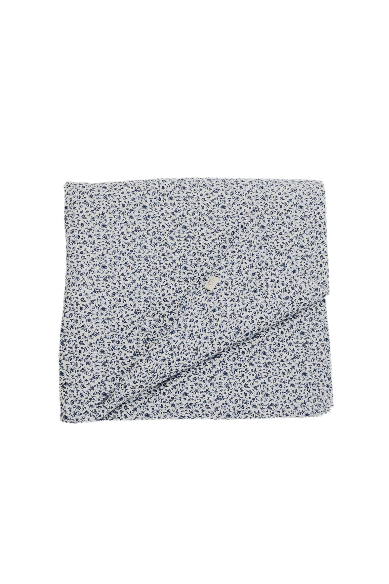 Quilted crib blanket with a floral pattern, hand-tufted with a puffy padded texture.
