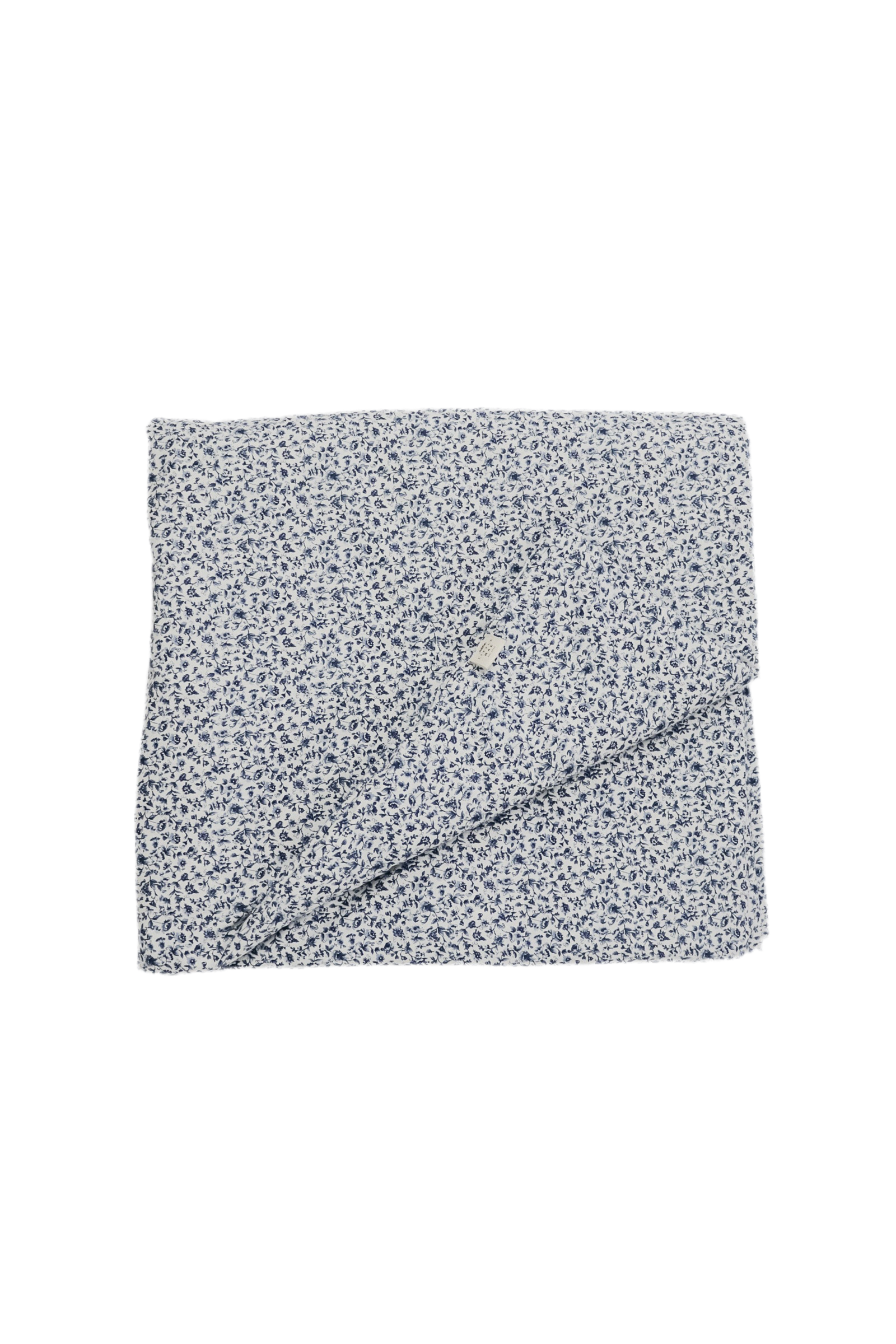 Quilted crib blanket with a floral pattern, hand-tufted with a puffy padded texture.