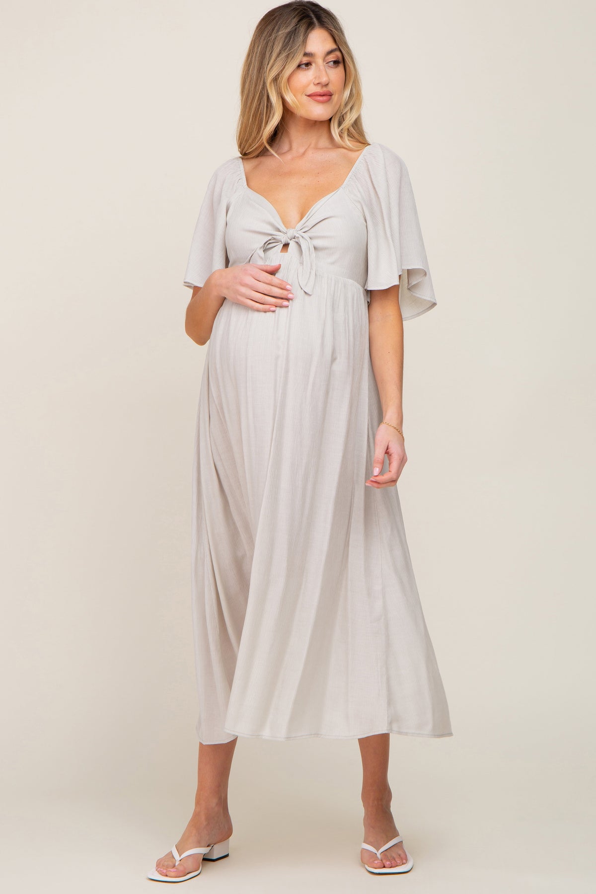 Grey maternity midi dress with v-neckline, front tie, front cutout, and short ruffle sleeves