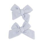 Two blue muslin bow hair clips in a matching set