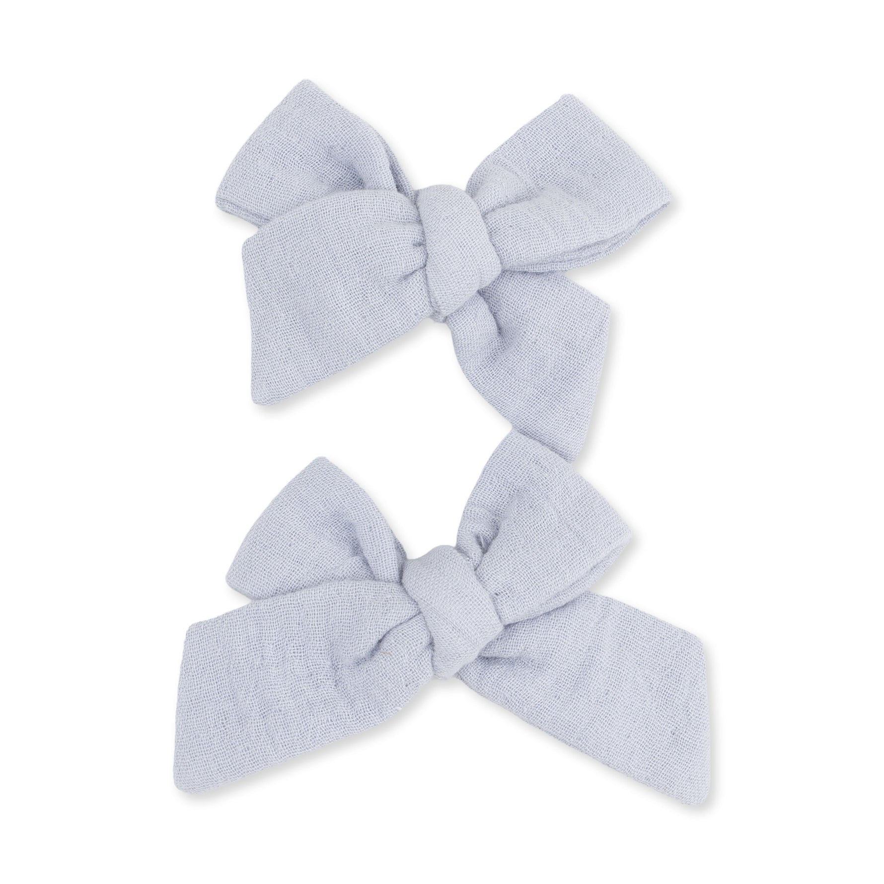 Two blue muslin bow hair clips in a matching set